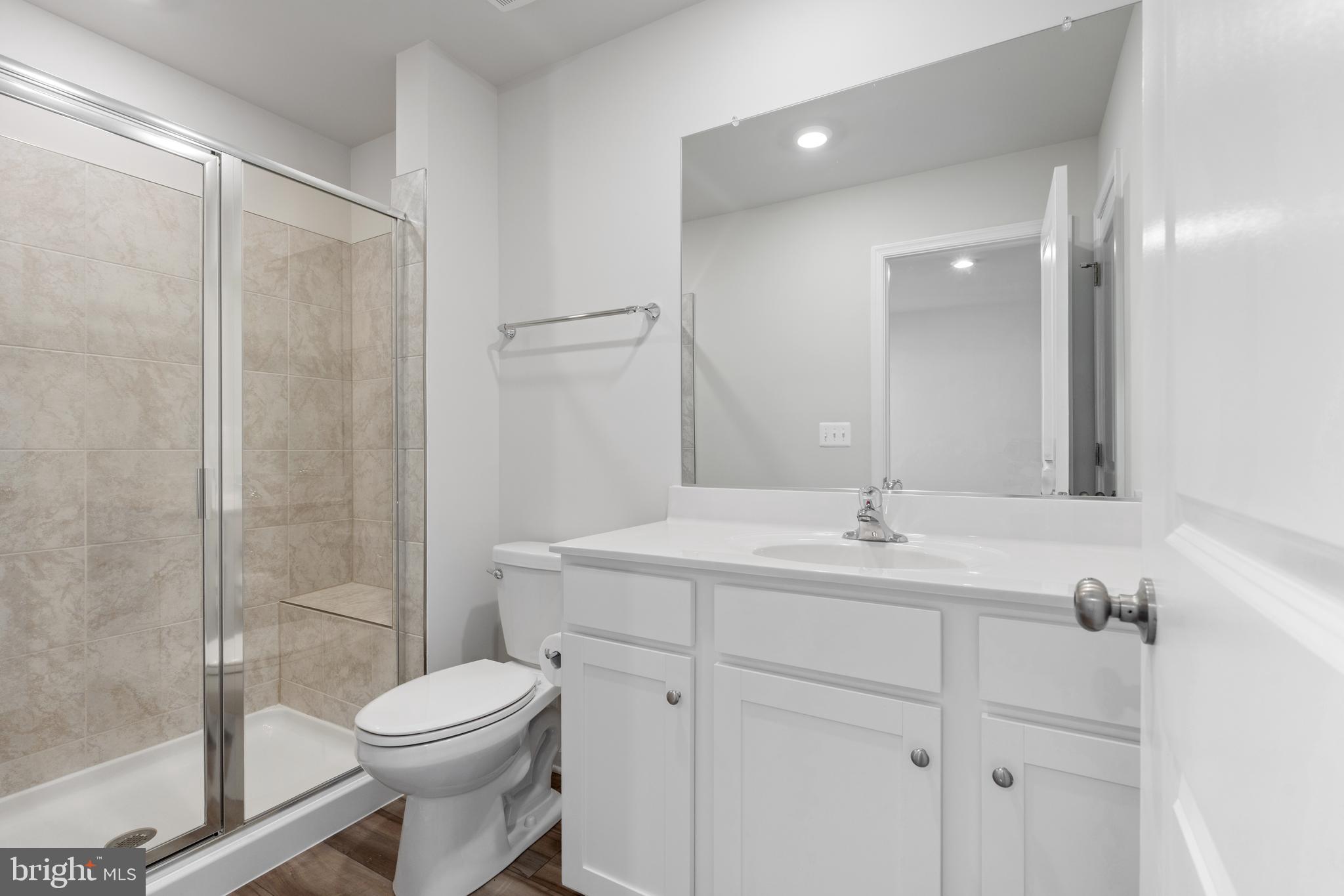 271 Sandy Btm Circle Ranson, WV 25438 - Photo 11 of 25 a bathroom with a toilet a sink a mirror and a shower