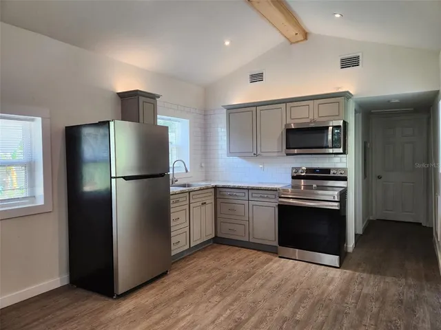 a kitchen with a refrigerator stainless steel appliances and cabinets