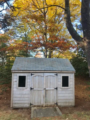 a view of a small house with a large tree