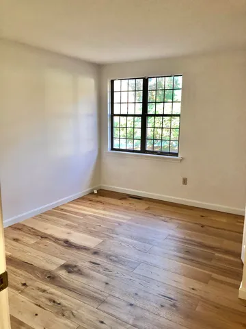 a view of a room with wooden floor and cabinet