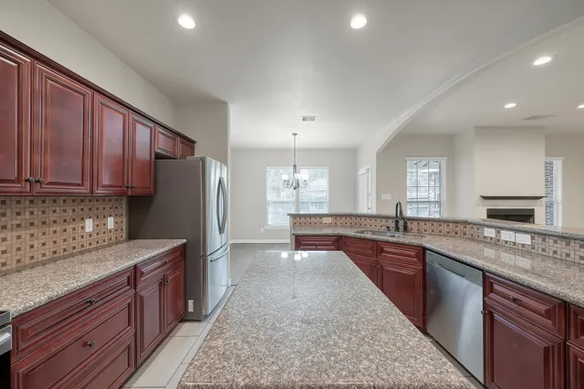 a view of a hallway with wooden floor and a kitchen