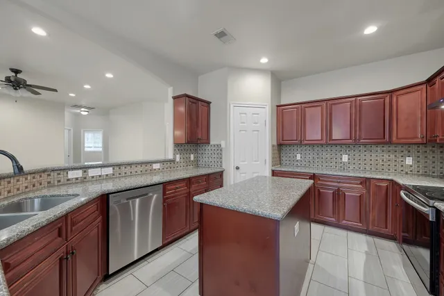 a view of an empty room with a chandelier fan