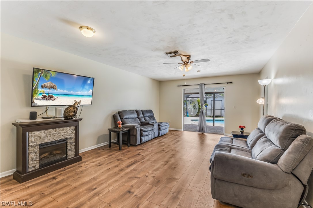 18454 Geranium Road Fort Myers, FL 33967 - Photo 6 of 17 a living room with furniture a fireplace and a flat screen tv