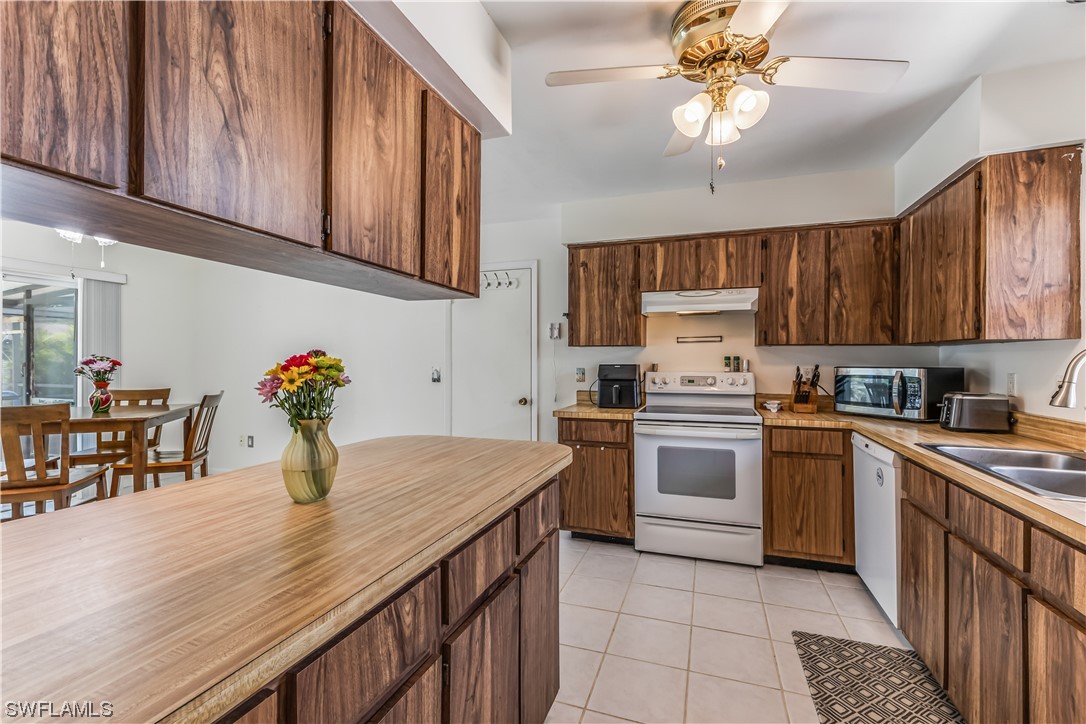 18454 Geranium Road Fort Myers, FL 33967 - Photo 9 of 17 a kitchen with stainless steel appliances granite countertop wooden cabinets a stove a sink and dishwasher