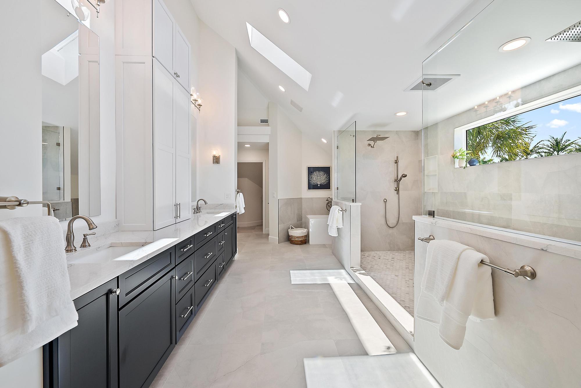 19 Island Road Sewall's Point, FL 34996 - Photo 22 of 50 a large bathroom with a double vanity sink and a mirror