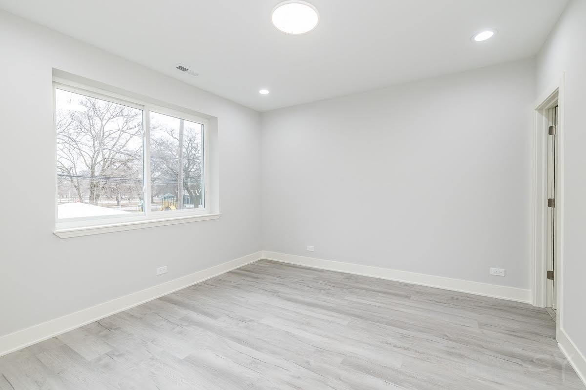 1232 South Fairfield Avenue, Unit 2 Chicago, IL 60608 - Photo 5 of 10 an empty room with wooden floor and windows