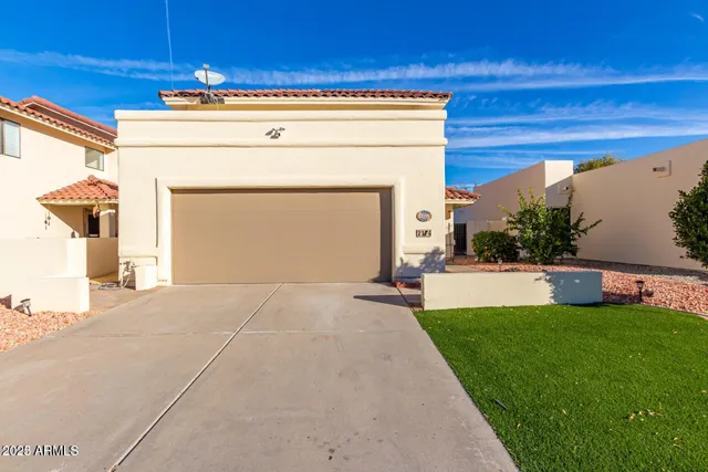 a view of a house with a yard and a garage