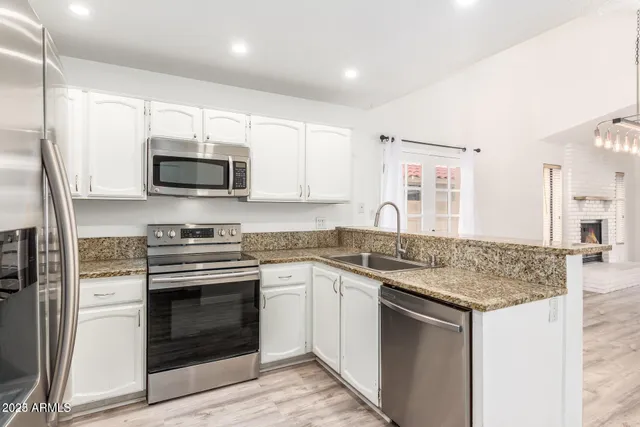 a kitchen with stainless steel appliances granite countertop a stove top oven a sink and a microwave