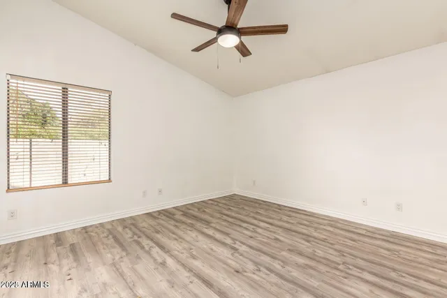 an empty room with a window and a ceiling fan