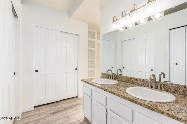 a bathroom with double vanity sinks and a mirror