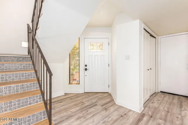 a view of a hallway with wooden floor and entryway