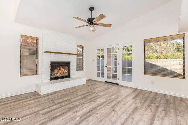 a view of empty room with wooden floor and fireplace
