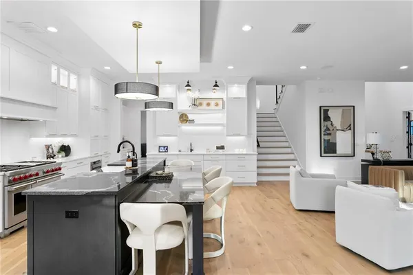 a living room with furniture a flat screen tv and kitchen view