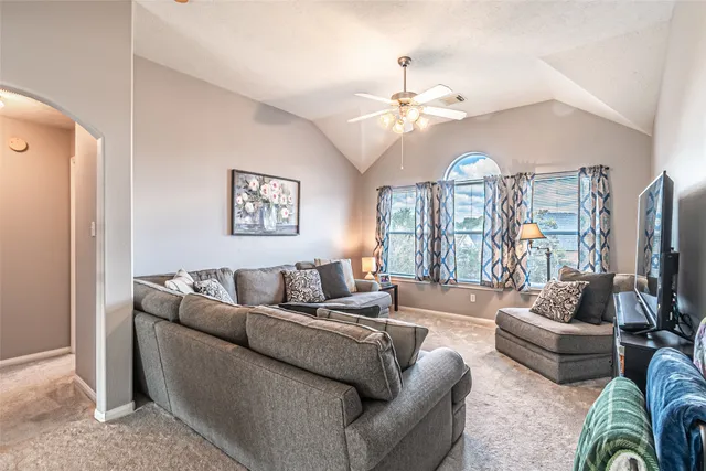 a living room with furniture ceiling fan and a window