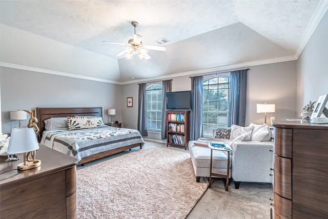 a bedroom with a bed and large windows