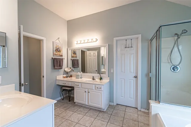 a en suite bathroom with a double vanity sink a mirror and a bathtub