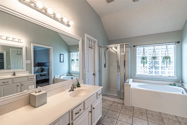 a spacious bathroom with a tub sink shower and mirror