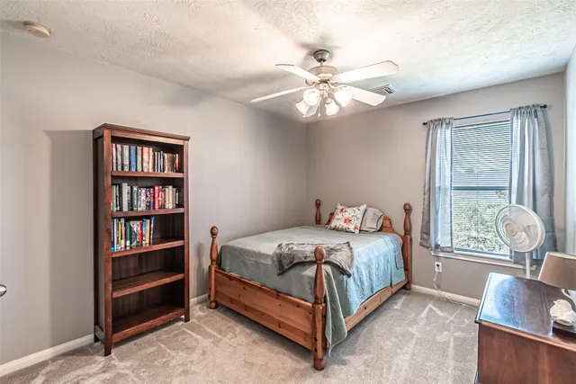 a bedroom with a bed next to a window and a chandelier