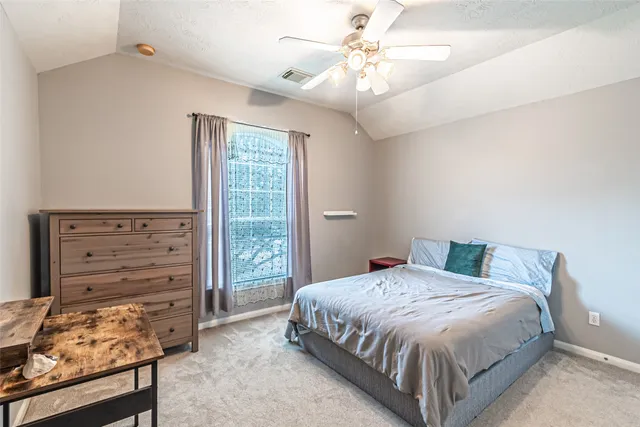 a bedroom with a bed dresser and a window