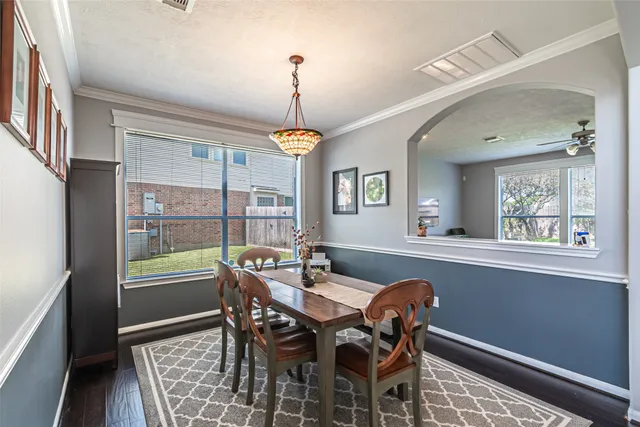a dining room with furniture a chandelier and wooden floor