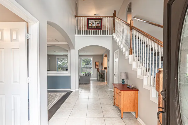 a view of a hallway with a livingroom and a staircase