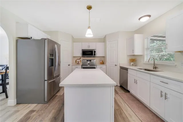 a kitchen with refrigerator a sink and microwave