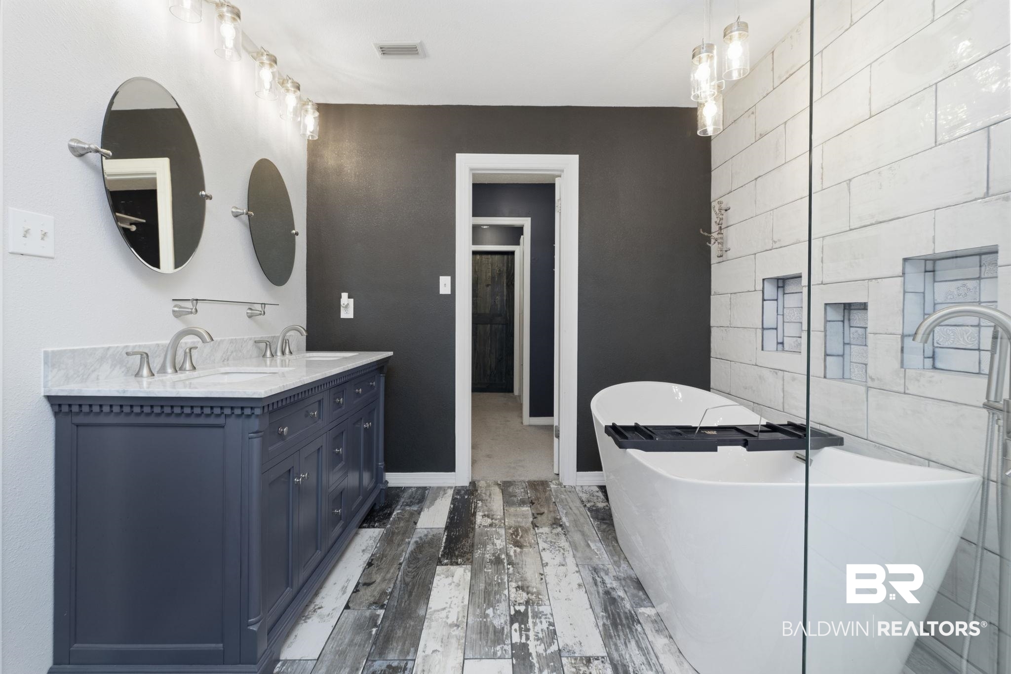 10670 Jeff Hamilton Road Mobile, AL 36695 - Photo 36 of 43 Bathroom featuring tile walls, double vanity, a freestanding bath, an accent wall, and light wood-style flooring
