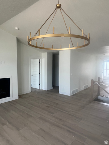 4740 West 25 North West Point, UT 84015 - Photo 8 of 15 Spacious interior featuring a large gold-finish chandelier, light wood-finish flooring, a contemporary fireplace, white baseboards, and a modern stair railing
