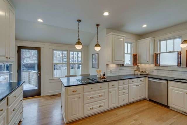 a kitchen with granite countertop kitchen island white cabinets and stainless steel appliances