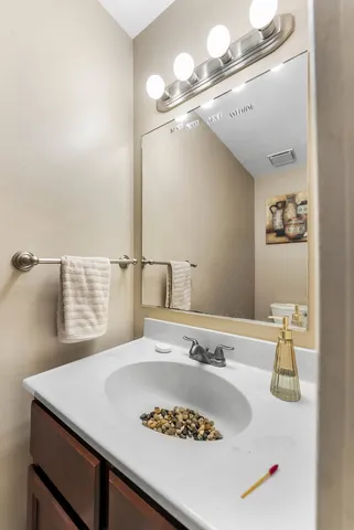 a bathroom with a sink vanity and a mirror