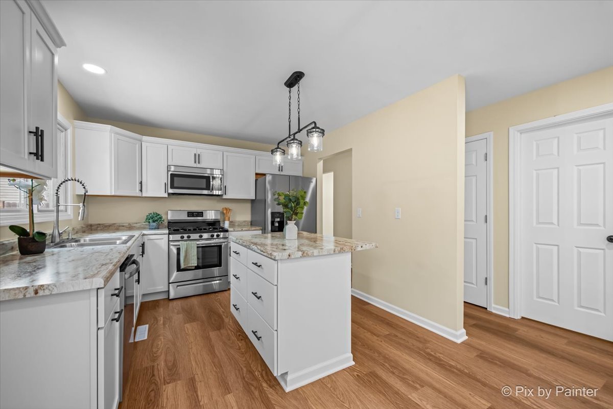 676 Concord Drive Crystal Lake, IL 60014 - Photo 9 of 38 a kitchen with stainless steel appliances a stove top oven a sink dishwasher and a refrigerator with wooden floor