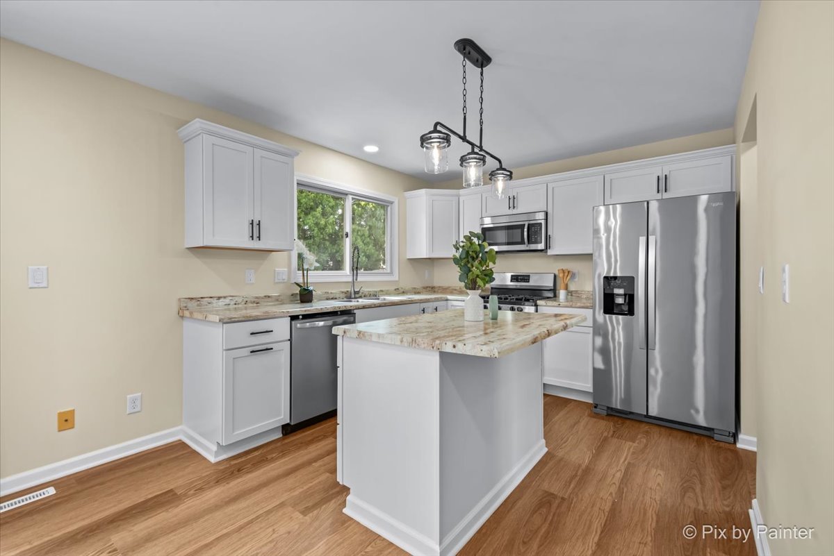 676 Concord Drive Crystal Lake, IL 60014 - Photo 10 of 38 a kitchen with stainless steel appliances granite countertop a refrigerator a sink dishwasher a stove and white cabinets with wooden floor
