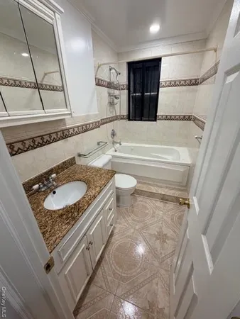 a bathroom with a granite countertop sink a toilet and a mirror
