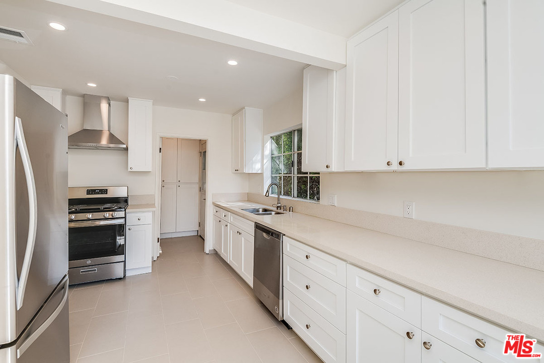 148 Le Doux Road Beverly Hills, CA 90211 - Photo 6 of 22 a kitchen with stainless steel appliances a refrigerator sink and stove