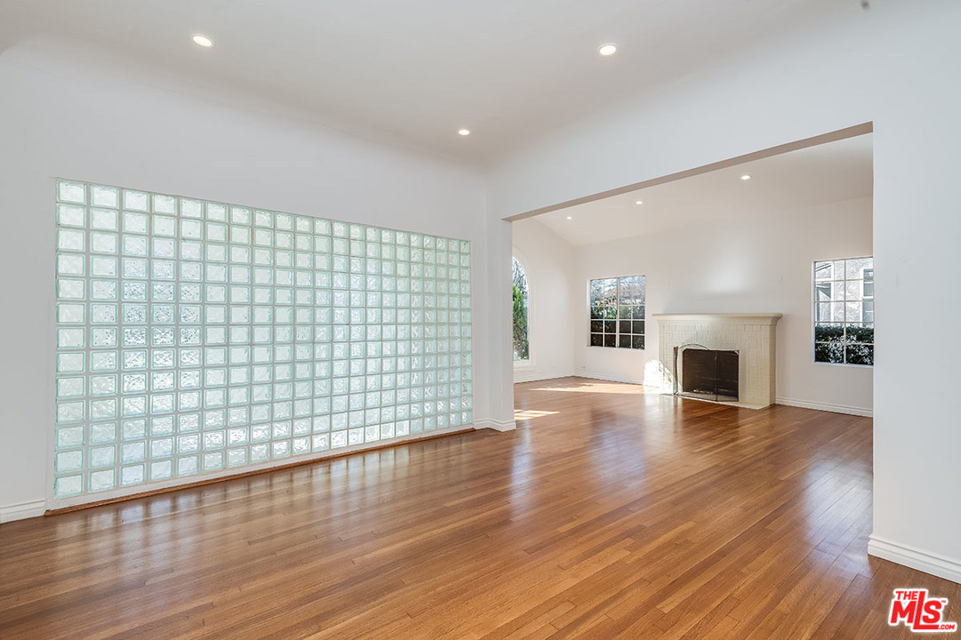 148 Le Doux Road Beverly Hills, CA 90211 - Photo 8 of 22 an empty room with wooden floor and fireplace