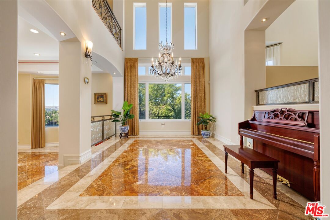 22470 Sueno Road Woodland Hills, CA 91364 - Photo 14 of 18 a living room with a table or chandelier and wooden floor