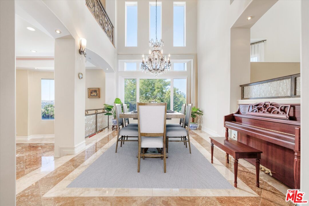 22470 Sueno Road Woodland Hills, CA 91364 - Photo 5 of 18 a dining room with wooden floor a chandelier a wooden table and chairs