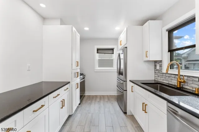 a kitchen with granite countertop a sink stove and refrigerator