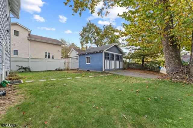 a view of a house with a big yard and large tree