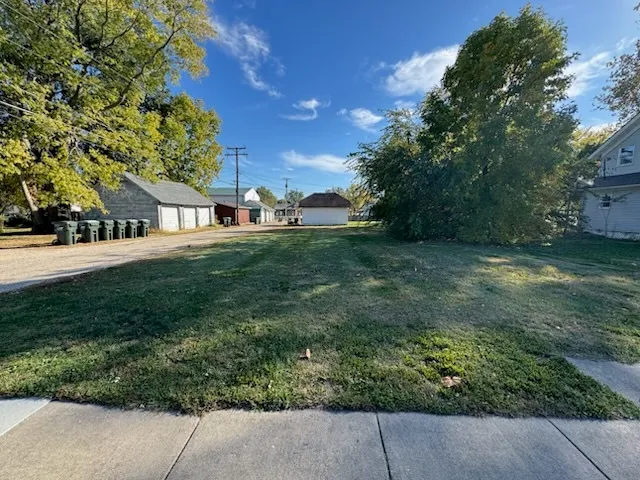 a view of a yard with plants and trees