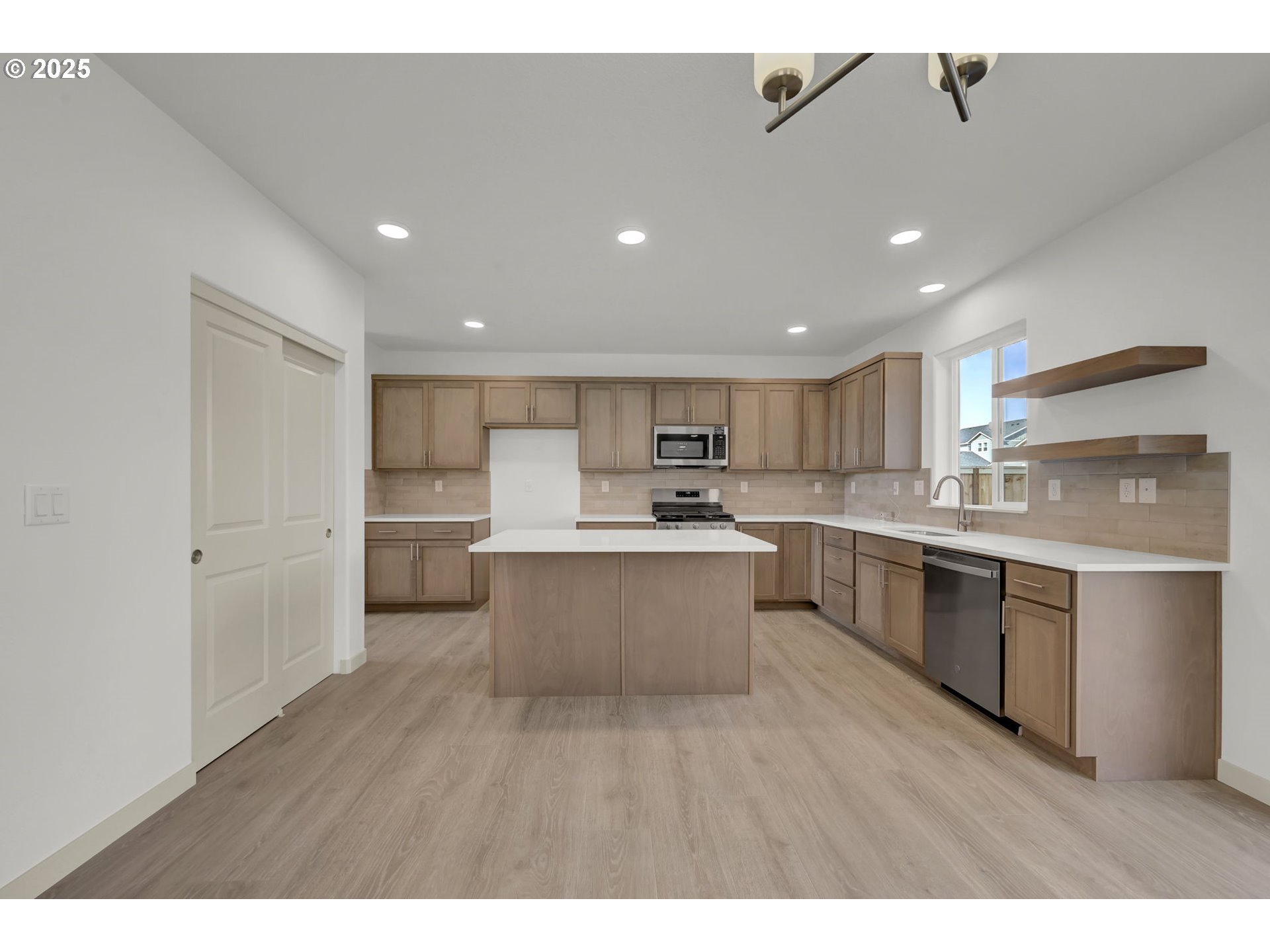 5653 Magnificence Way Eugene, OR 97402 - Photo 2 of 44 a large kitchen with a large counter top a sink stainless steel appliances and cabinets