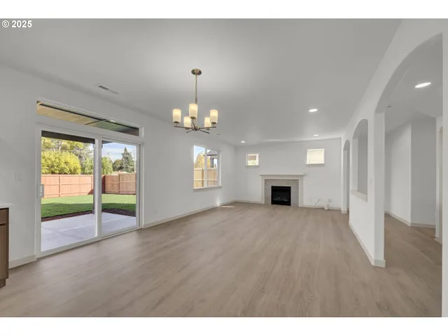 a view of an empty room with a fireplace and a window