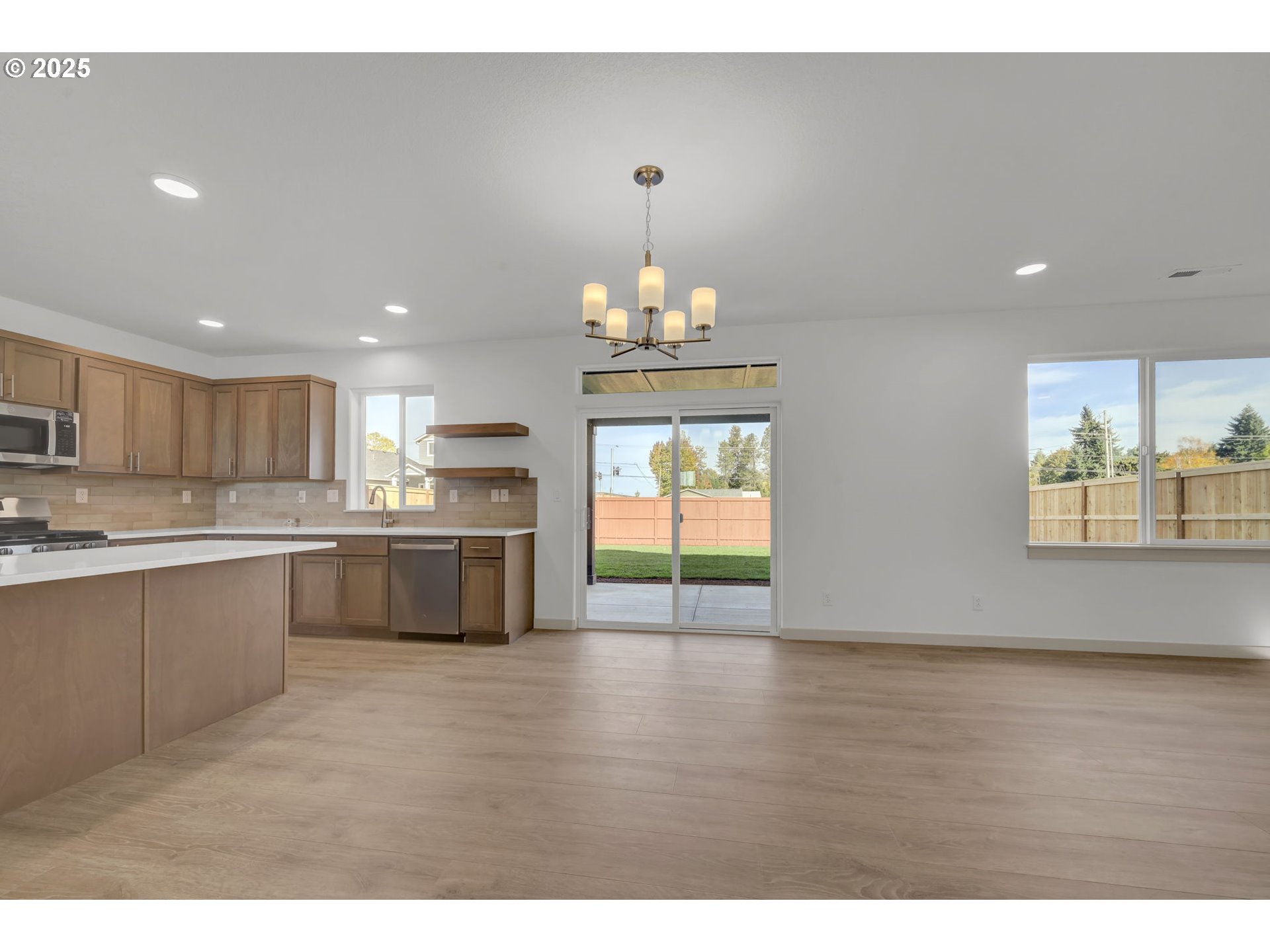 5653 Magnificence Way Eugene, OR 97402 - Photo 6 of 44 a large kitchen with granite countertop a stove a sink a refrigerator and a microwave