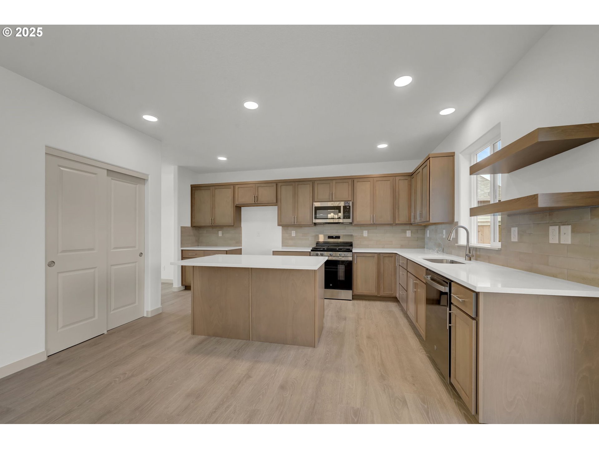 5653 Magnificence Way Eugene, OR 97402 - Photo 8 of 44 a kitchen with stainless steel appliances kitchen island sink refrigerator and cabinets