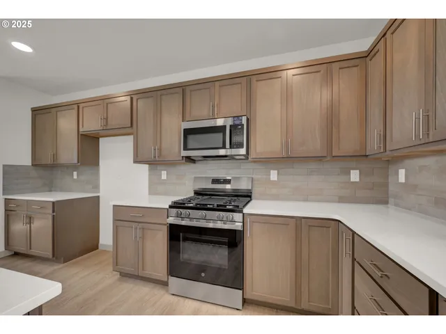 a kitchen with kitchen island granite countertop white cabinets and stainless steel appliances