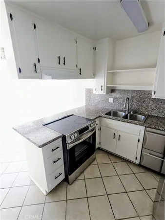 a kitchen with granite countertop white cabinets and appliances
