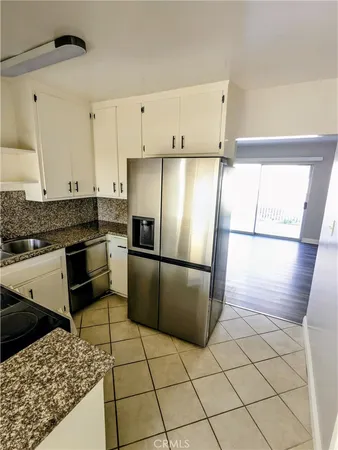 a kitchen with a refrigerator a stove a sink and a counter top