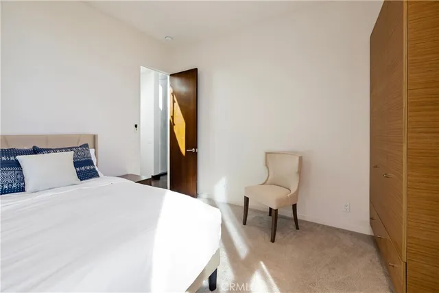 a spacious bedroom with a bed and a chair