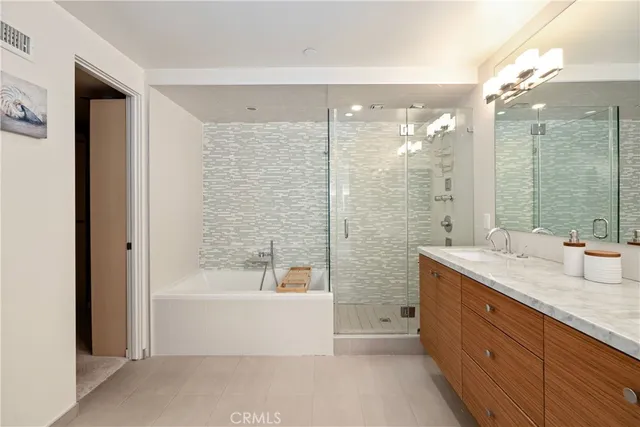 a bathroom with a granite countertop sink mirror and a bathtub