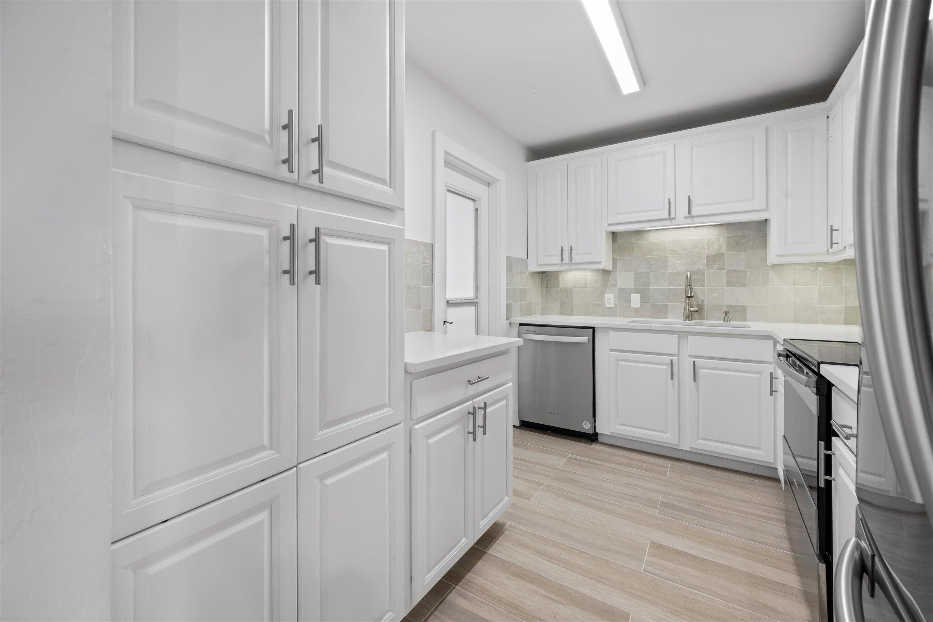 225 South Beach Road, Unit 102 Jupiter, FL 33469 - Photo 9 of 22 a kitchen with white cabinets and white appliances